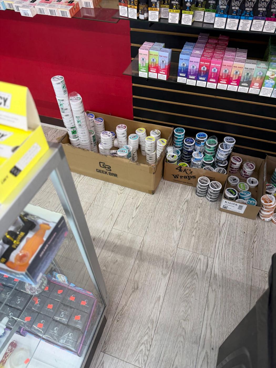 E-liquid bottles and nicotine pouches stacked on the slatwall.