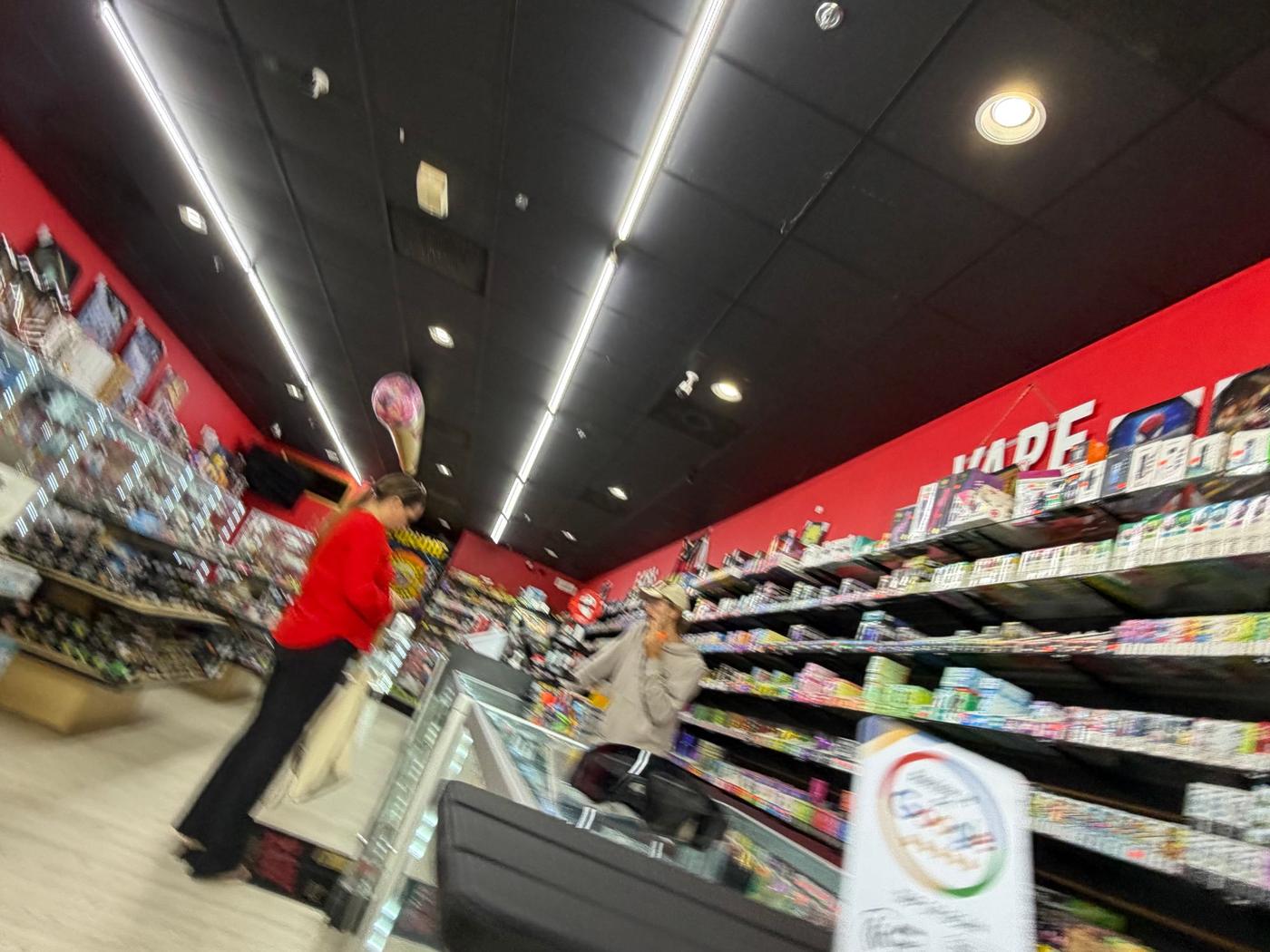 Inside Supreme Smoke And Vape: the length of the counter, lit display cases on both sides.